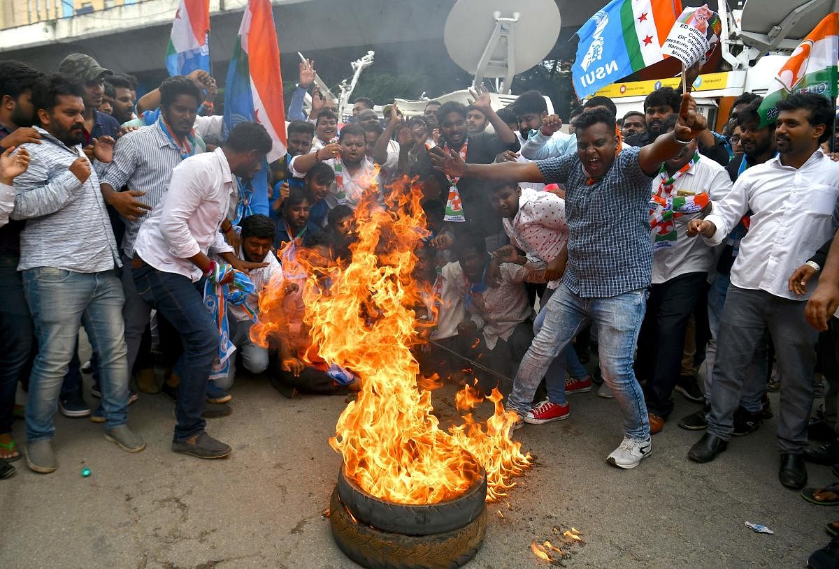 Members of the Karnataka Congress burn tyres and shout slogans against Prime Minister Narendra Modi and Home Minister Amit Shah during a protest staged by the party in Bangalore. AFP photo