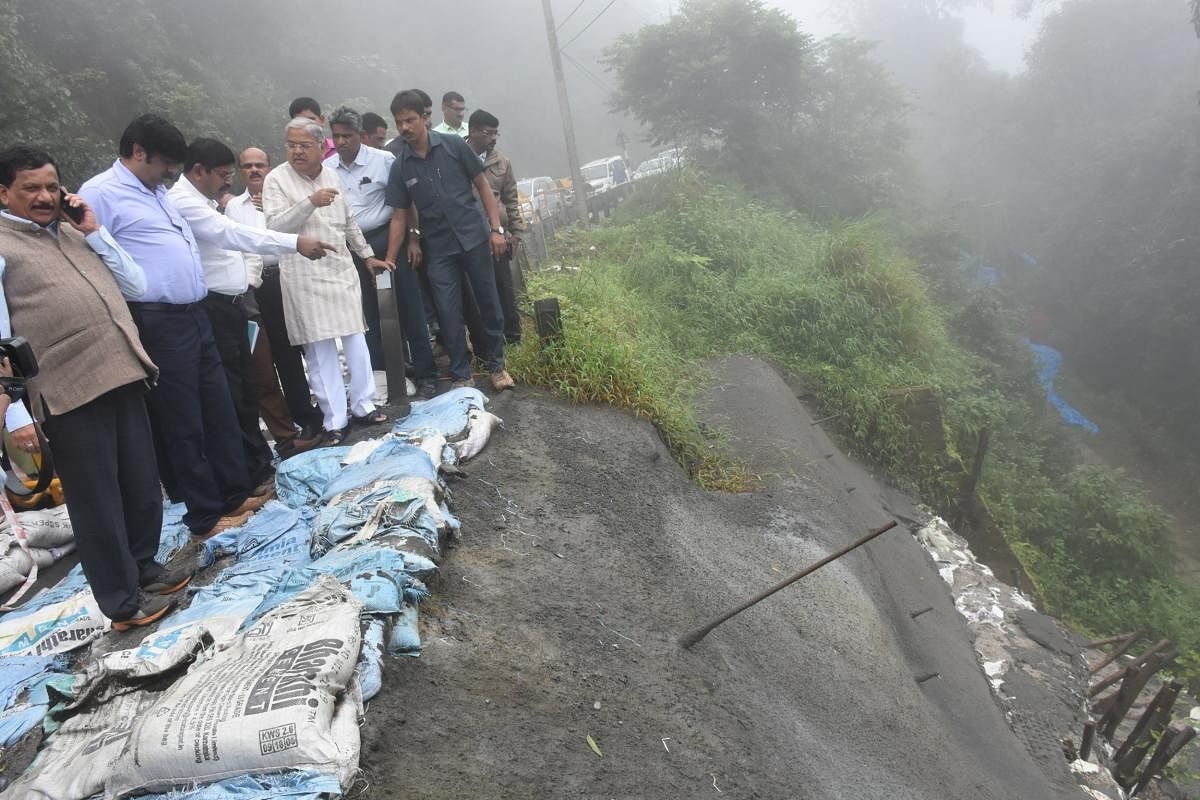 Deputy Chief Minister Govind M Karjol inspects a national highway near Madikeri, which had caved-in following rain last year.