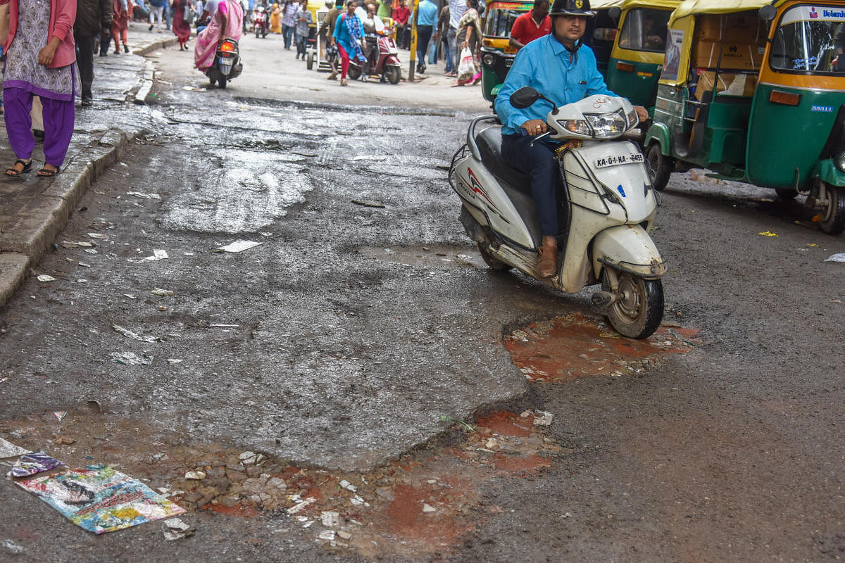 Potholes seen on Avenue Road in Bengaluru on Thursday. (DH Photo by S K Dinesh)
