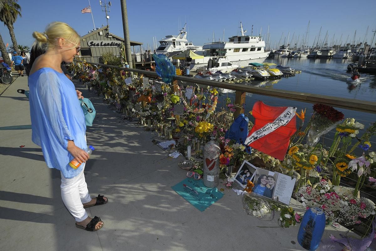 Anja Jaenschke, visits a growing memorial to those who died aboard the dive boat Conception as its sister boat Vision sits in the background. (AP/PTI Photo)