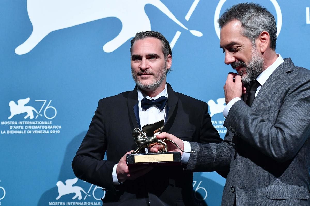 US director Todd Phillips (R) and US actor Joaquin Phoenix, hold the Golden Lion award for Best Film that Philipps received for the movie "Joker" during the awards ceremony winners photocall of the 76th Venice Film Festival on September 7, 2019 at Venice