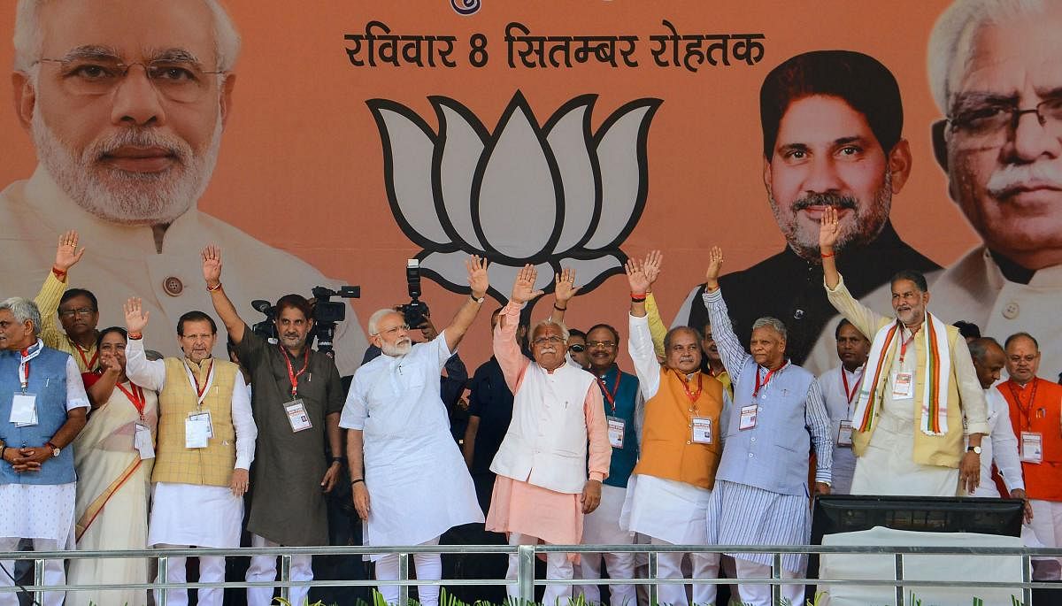 Prime Minister Narendra Modi with Haryana Chief Minister Manohar Lal and other BJP leaders waves at the crowd during a public rally in Rohtak. PTI