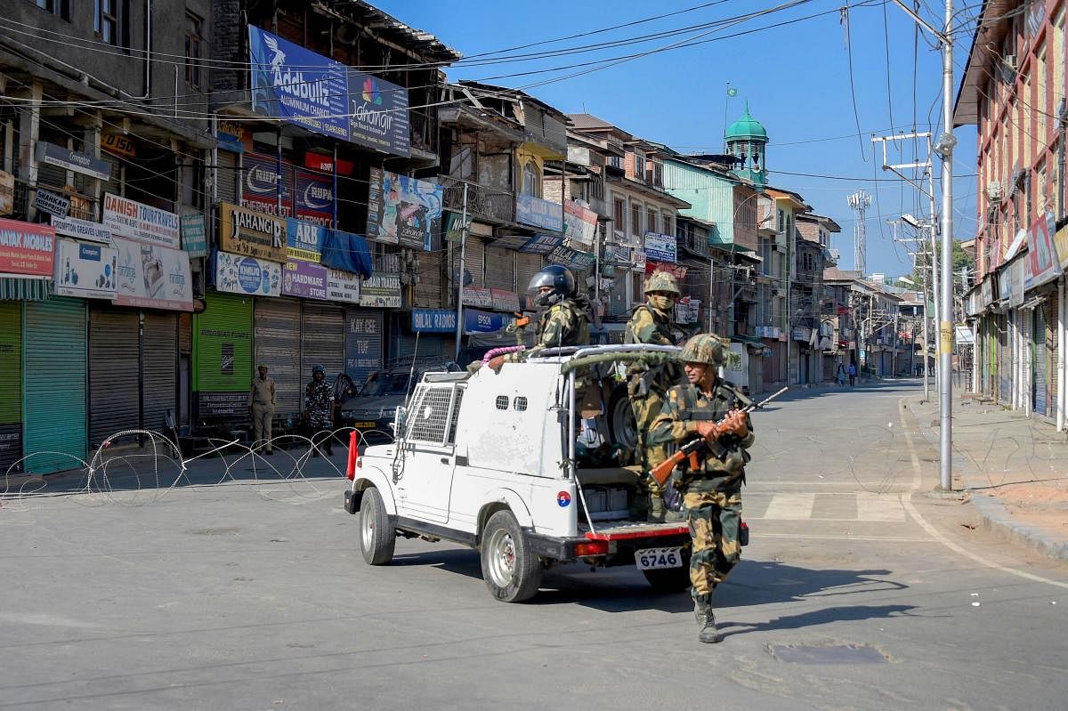 Security personnel stands guard at a deserted road during restrictions, after the abrogration of Article 370 and bifurcation of state, in Srinagar. PTI Photo