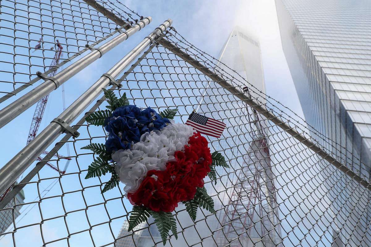 Flowers are seen left on a fence near the One World Trade Center tower on the 18th anniversary of the September 11, 2001 attacks in lower Manhattan in New York, U.S., September 11, 2019. (Photo by Reuters)