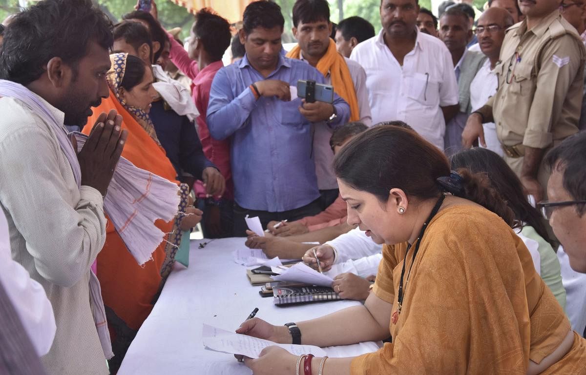 Amethi: Union Minister and Amethi MP Smriti Irani listens to the problems of the villagers, in Amethi, Wednesday, Sept. 11, 2019. (PTI Photo)