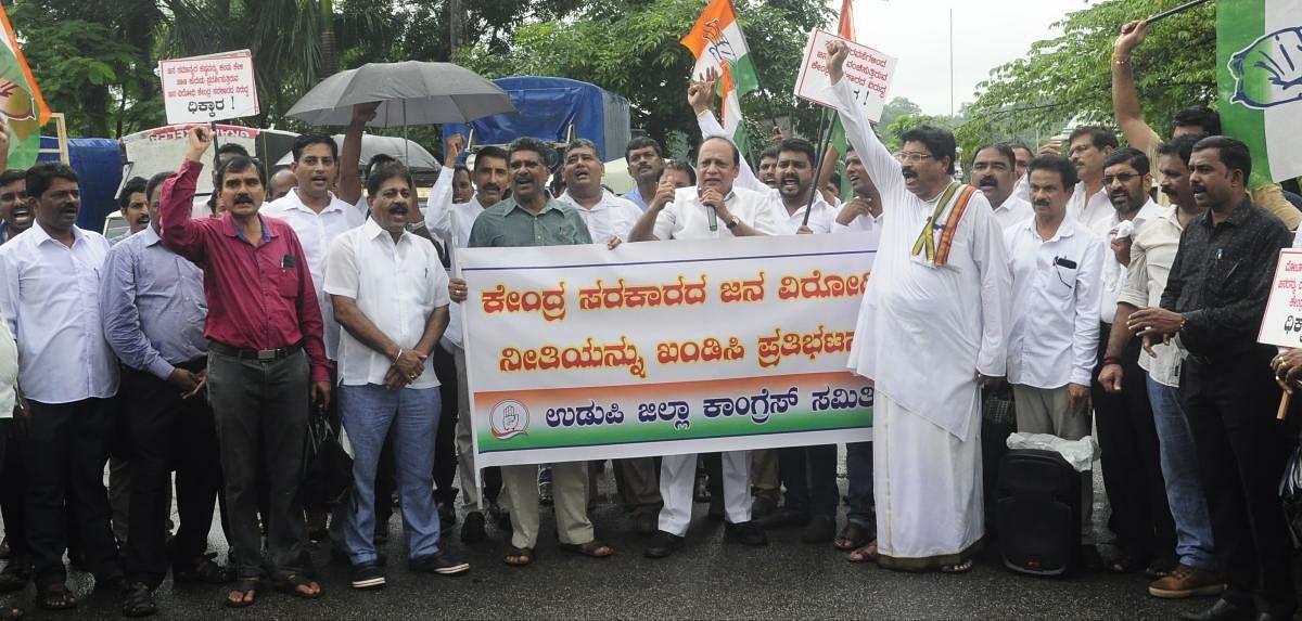 Former minister Vinay Kumar Sorake addresses leaders and members of district Congress committee during a protest against the delay in implementation of flood relief work in flood affected regions in North Karnataka at Martyrs Memorial in Udupi on Thursday