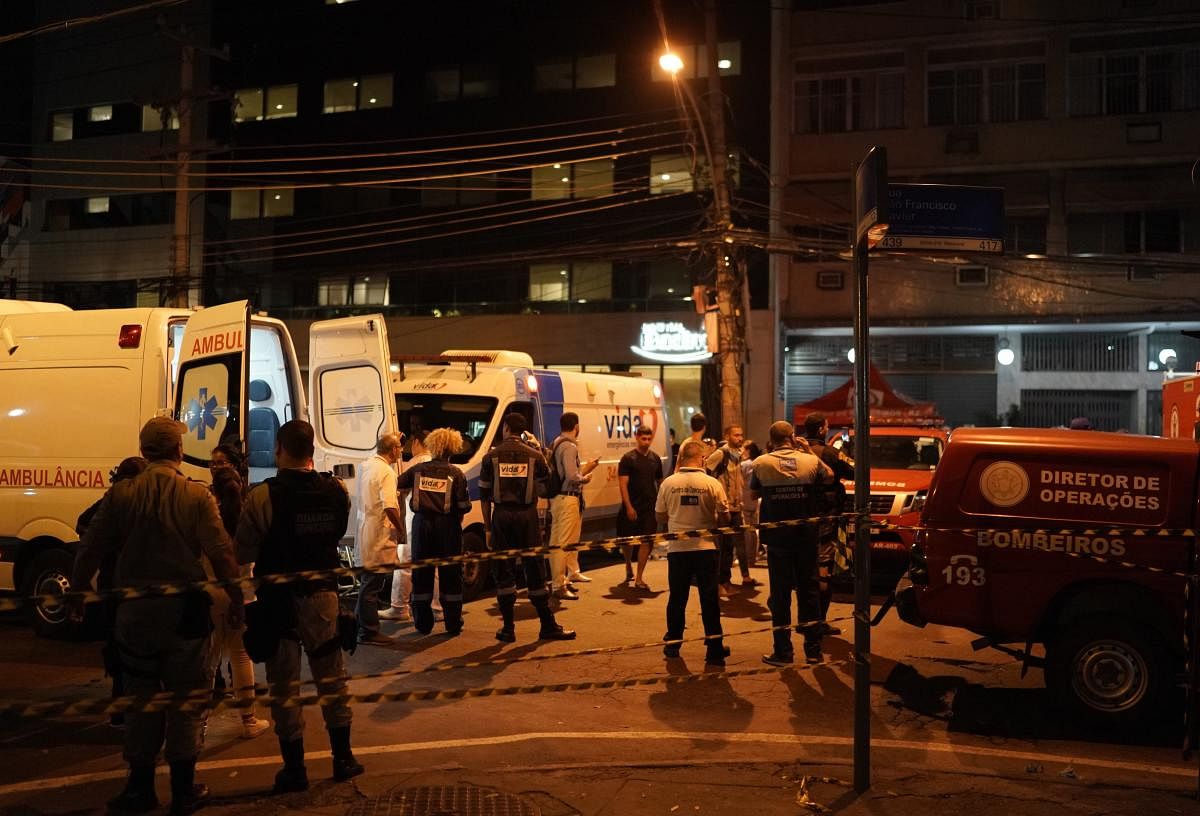 Personnel stand outside the hospital where a fire forced staff to evacuate in Rio de Janeiro, Brazil, Thursday, Sept. 12, 2019. The fire forced staff to hastily evacuate patients and temporarily settle some on sheets and mattresses in the street while fir