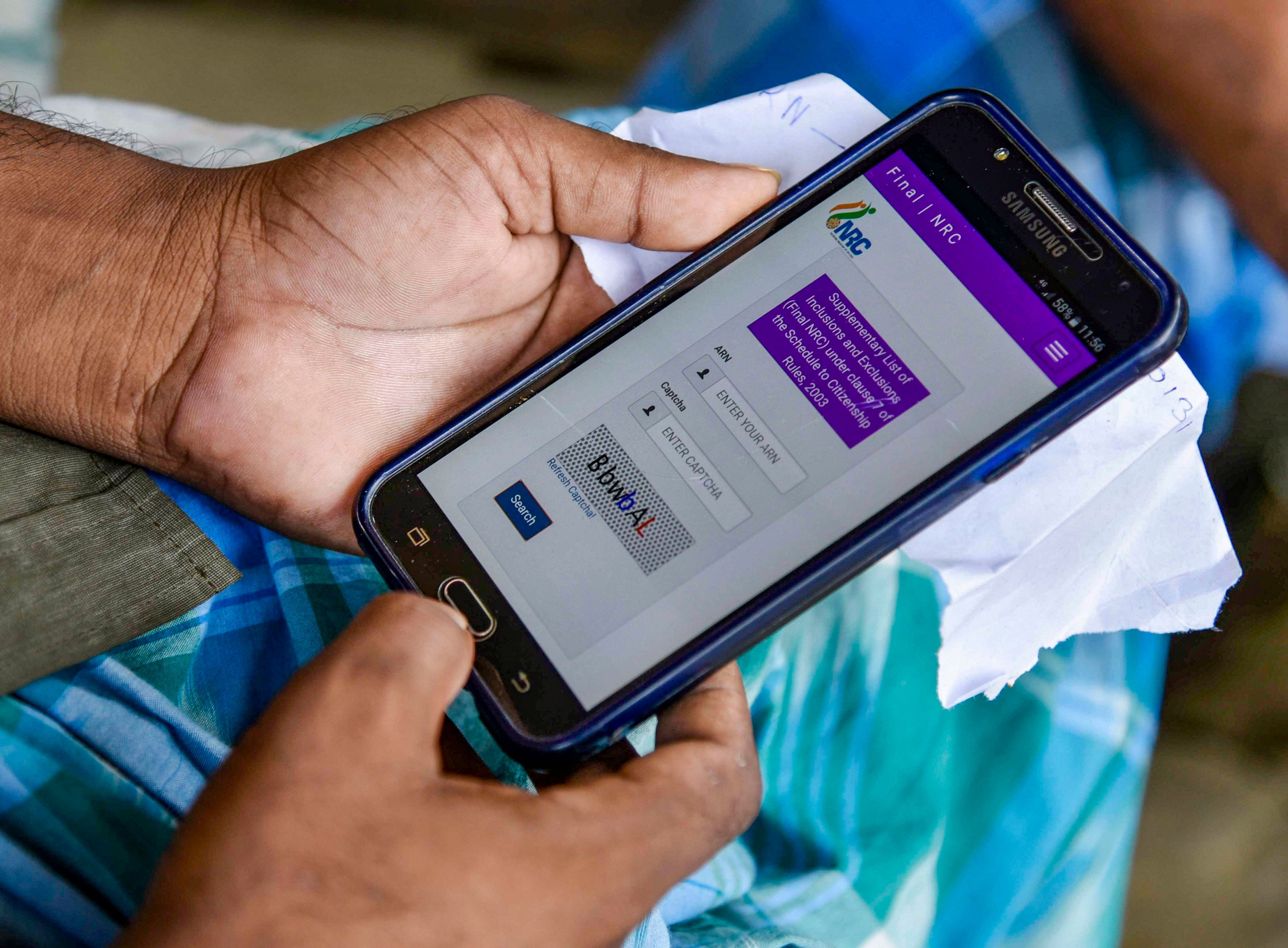A person checks the final list of NRC that was released today on a mobile phone. (PTI Photo)