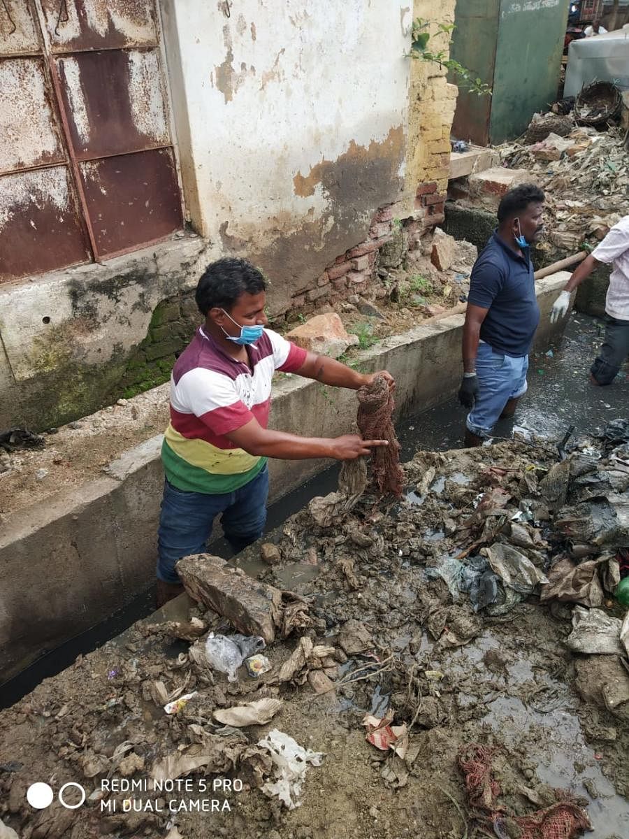 Volunteers clean up a drainage in Holealuru, Gadag