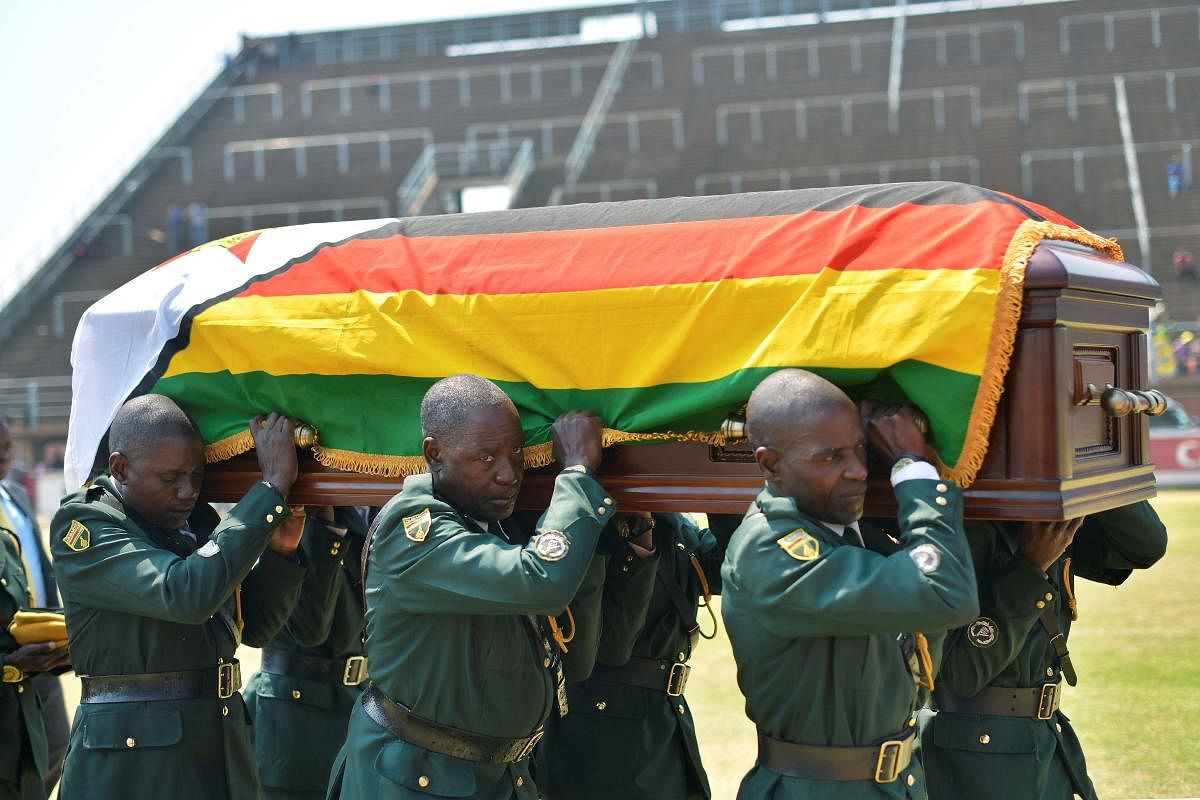 Soldiers in ceremonial uniform carry the casket of Zimbabwe's former President, the late Robert Mugabe after it arrived at Rufaro stadium. (AFP Photo)