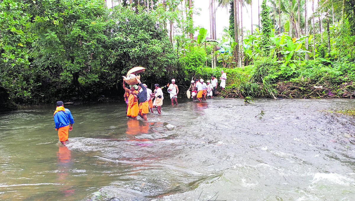 People carry the ‘Daiva Bhandara’ of Valpady Garadi, Moodbidri taluk, across the Arbi rivulet.