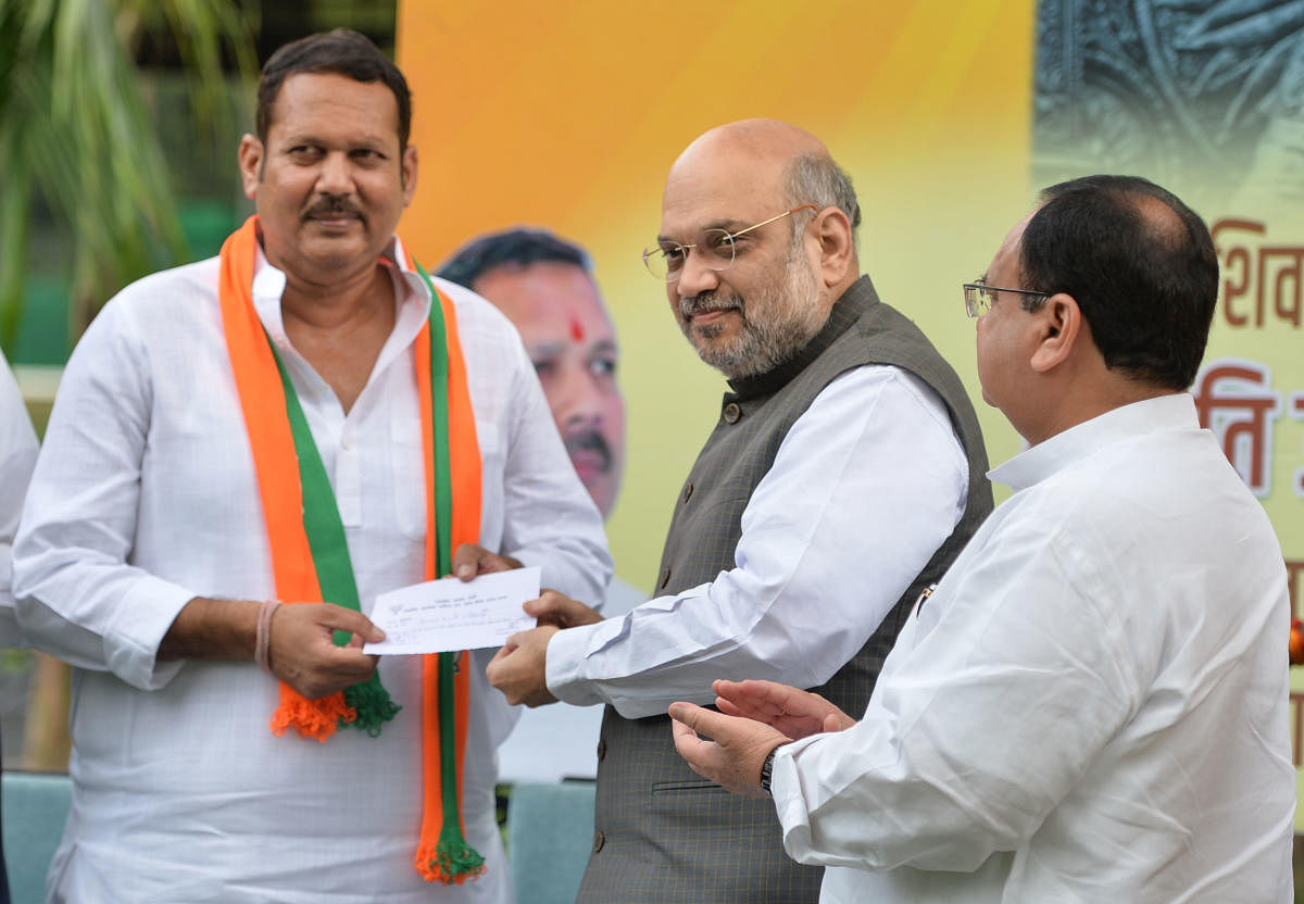 Home Minister Amit Shah gives party membership slip to senior NCP leader Udayanraje Bhosale, after the latter joined BJP. PTI file photo