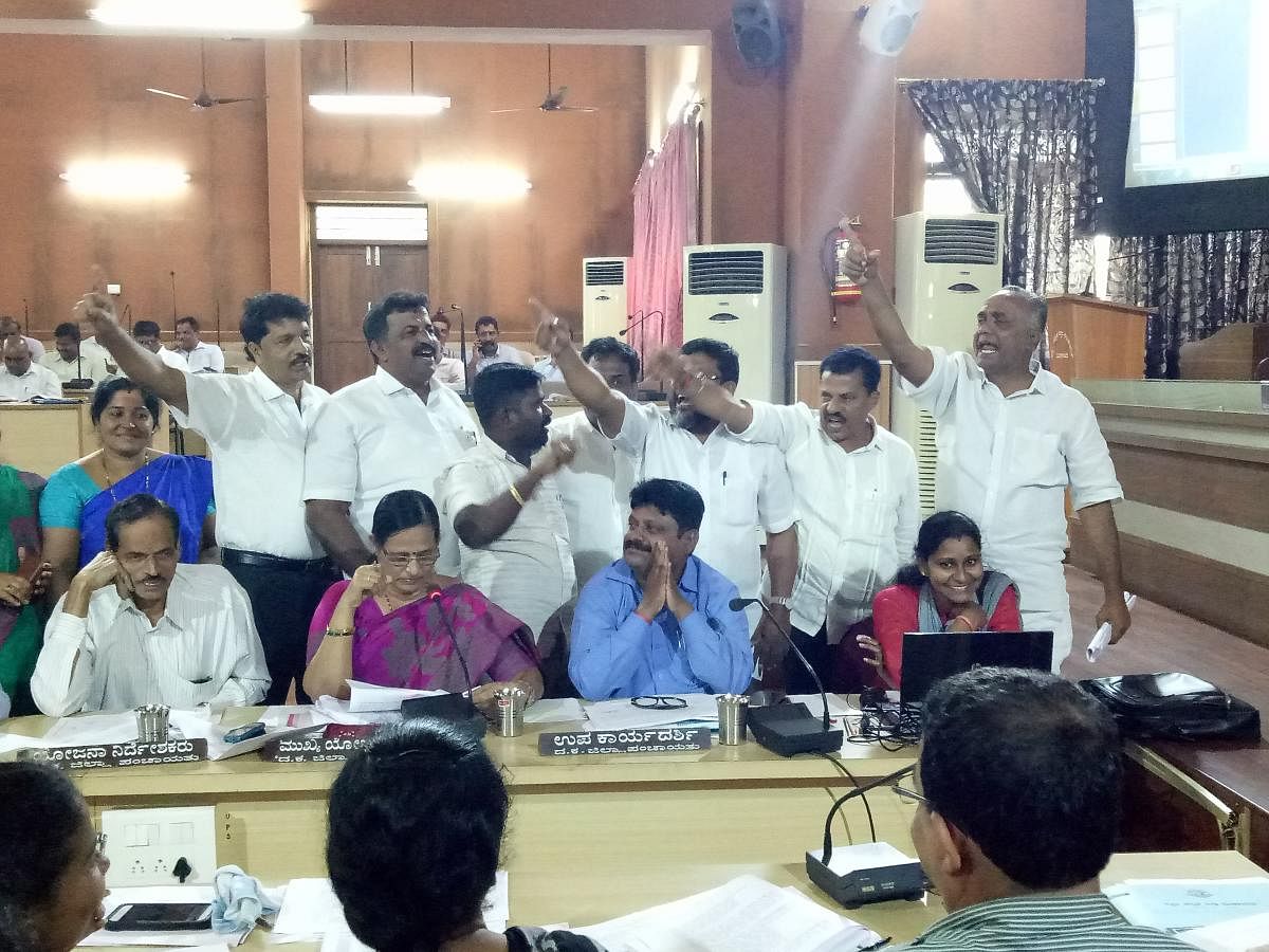 Zilla Panchayat Congress members raise slogans against the BJP in an attempt to prevent staff from reading out the Panchayat resolution to supersede Haleyangady Gram Panchayat at Nethravathi Hall at the Zilla Panchayat office in Mangaluru on Monday.