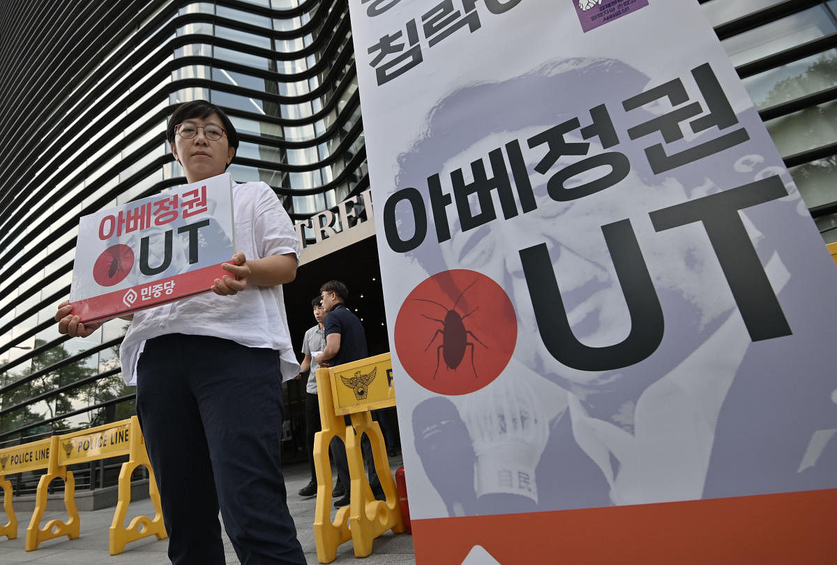 A South Korean protestor holds a placard reading "Abe's government Out," in a protest against Japan's decision to remove South Korea from a so-called white list of favoured export partners (AFP File Photo)