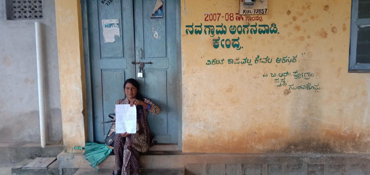 Anganwadi assistant K A Shantha stages a protest in front of Navagrama Anganwadi Centre in Kushalnagar, alleging harassment by teacher Kalavathi.