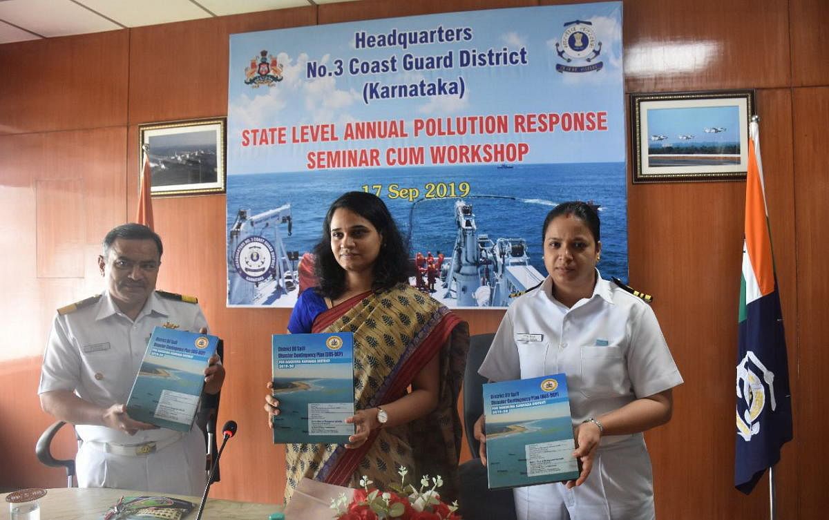 Deputy Commissioner Sindhu B Rupesh (centre) and Coast Guard Commander S S Dasila (left) release a book during a state-level annual pollution response seminar-cum-workshop organised at Coast Guard headquarters in Panambur on Tuesday.