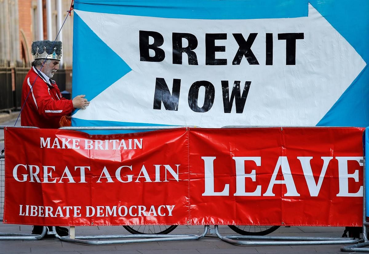 A pro-Brexit demonstrator stands with a "Brexit Now" and "Make Britain Great Again" banner outside the Supreme Court in central London, on the second day of the hearing into the decision by the government to prorogue parliament on September 18, 2019. Phot