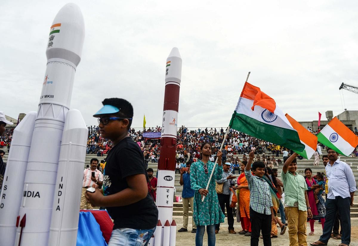 Students wave Indian national flags as the Indian Space Research Organisation's (ISRO) Chandrayaan-2 (Moon Chariot 2), with on board the Geosynchronous Satellite Launch Vehicle (GSLV-mark III-M1), has been launched in Sriharikota in the state of Andhra Pradesh on July 22, 2019. Photo credit: AFP