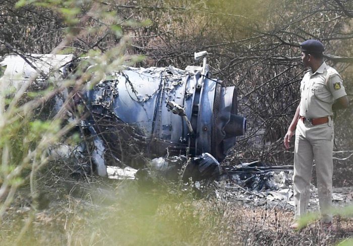 A police officer inspects the wreckage of the Mirage-2000 fighter aircraft after it crash landed at HAL airport, soon after taking-off for a training sortie in Bengaluru on Friday. (DH Photo/ B H Shivakumar)
