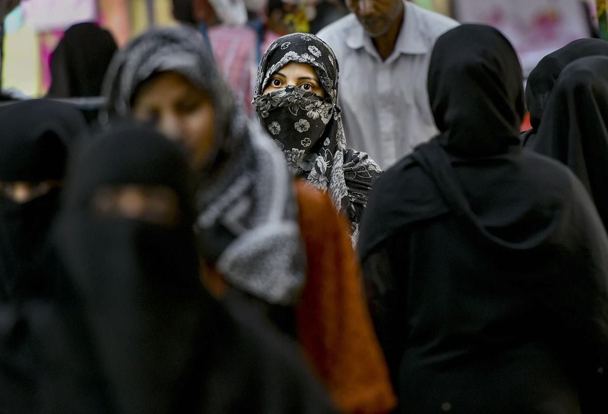 Muslim women walk in a market near Jama Masjid in New Delhi. (PTI File Photo)