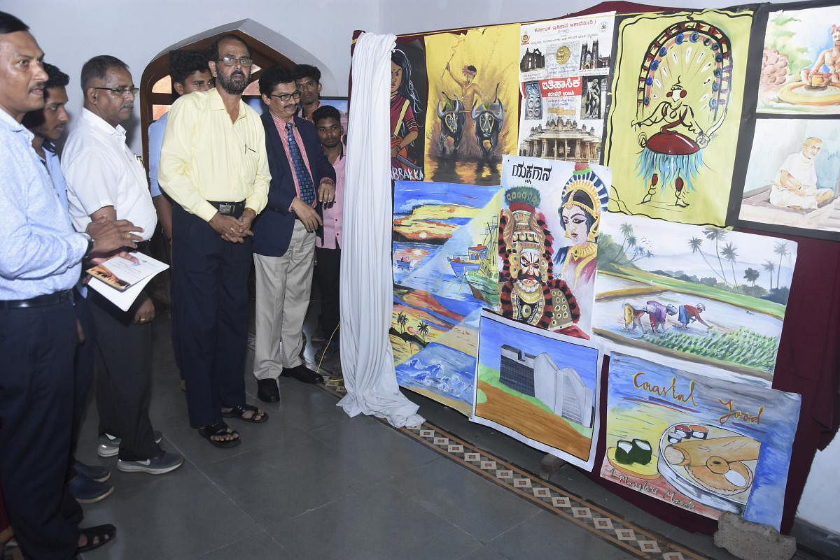 Mangalore University Vice Chancellor Prof P S Yadapadithaya unveils paintings by the students of University College, Mangaluru, during a seminar on Wednesday.