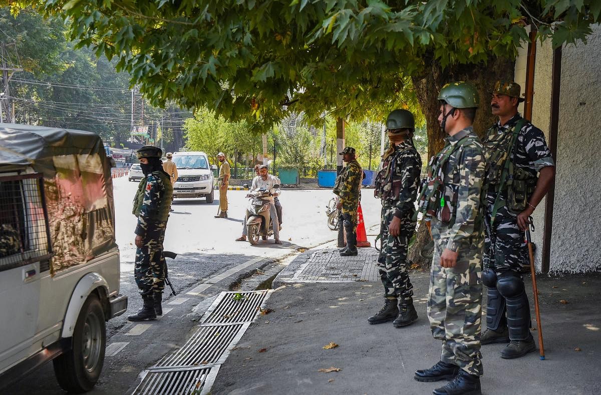 Police and CRPF personnel stand guard near the residence of National Conference President Farooq Abdullah, in Srinagar (PTI Photo)