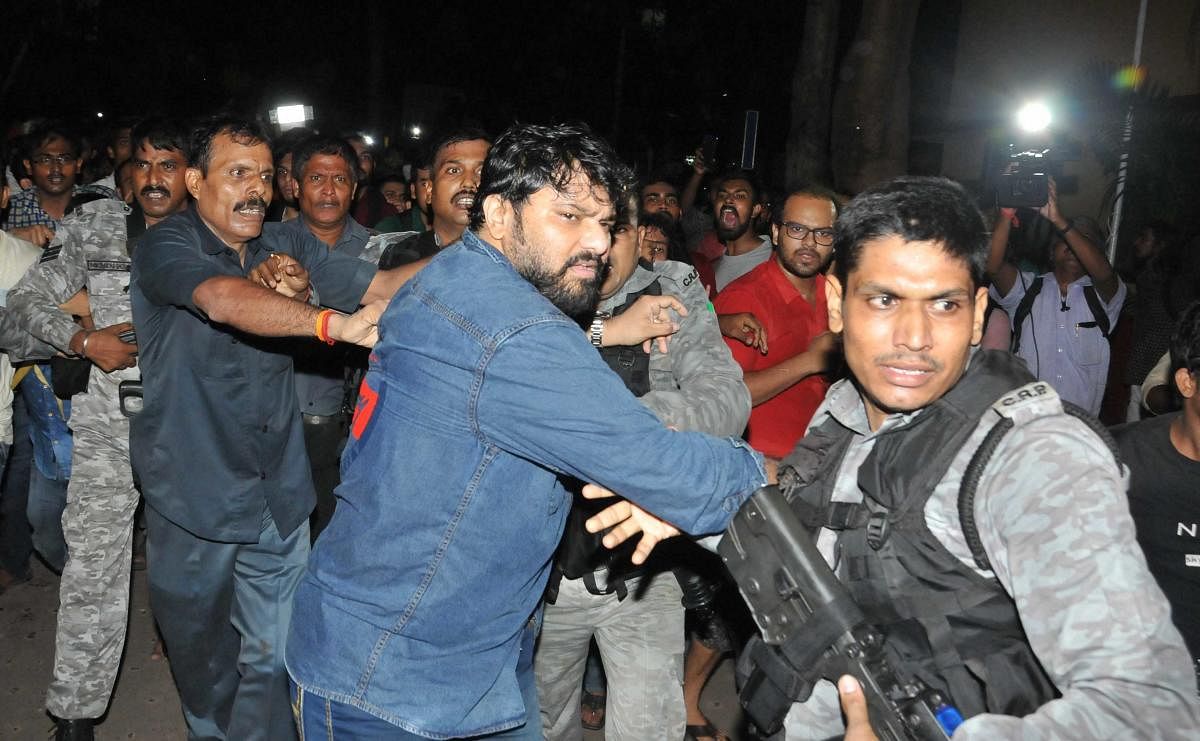 CRPF personnel try to rescue Babul Supriyo as he is heckled by left-wing students of Jadavpur University during ABVP seminar at the university campus. PTI