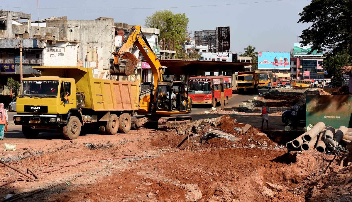 Earth movers digging the road near the Laxmi Circle in Dharwad on Sunday for laying drainage pipes.