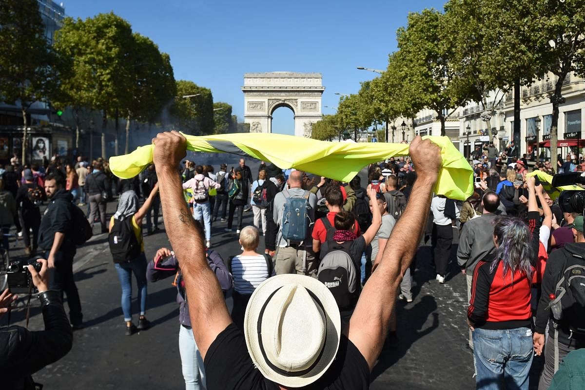 A man holds up a yellow vest in front of the Arc de Triomphe on the Champs Elysees avenue during an anti-government demonstration called by the "yellow vest" (gilets jaunes) movement, on September 21, 2019 in Paris. AFP
