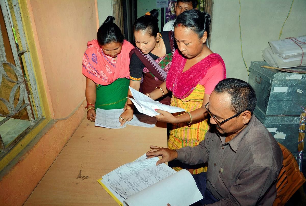 Bodo women check their names in the final list of National Register of Citizens (NRC), at an NRC Seva Kendra at Bagan Para in Baska district of Assam, Monday, Sept 2, 2019. (PTI Photo)