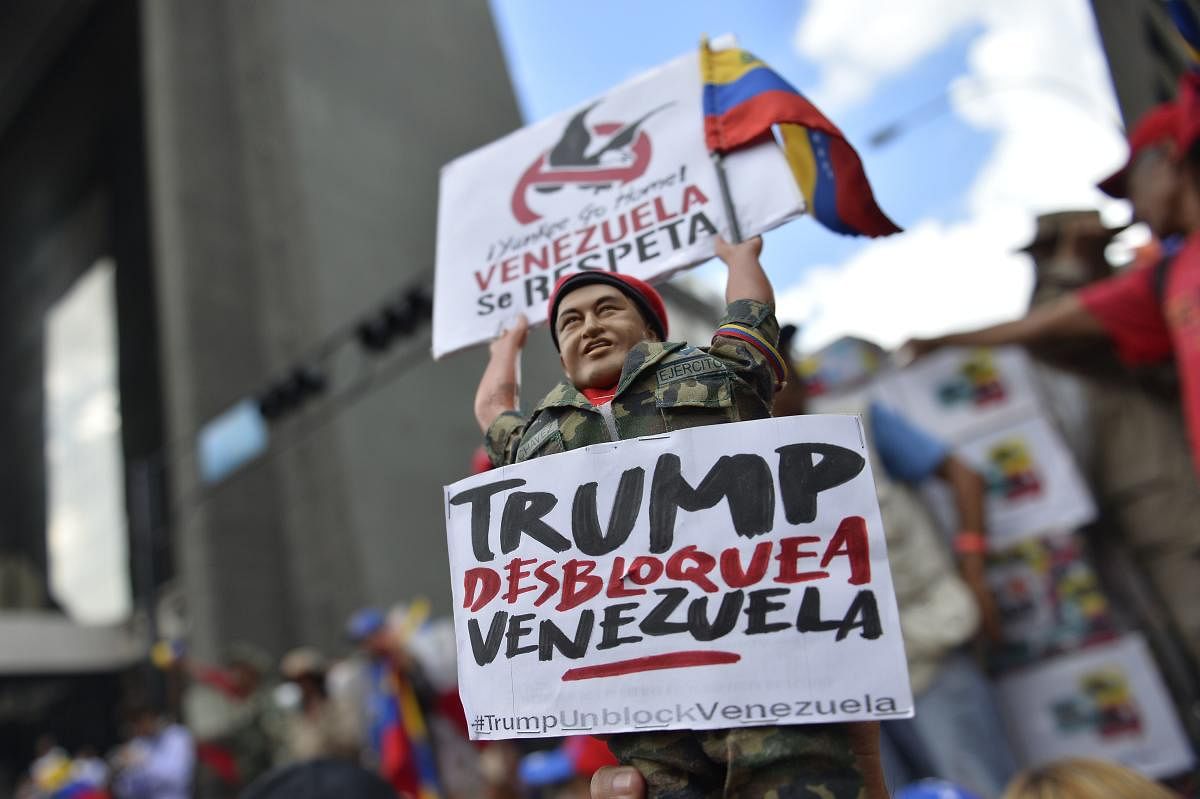 A supporter of Venezuela President Nicolas Maduro holds a figurine of late leader Hugo Chavez during a demonstration against the sanctions imposed by the US President Donald Trump, in the surroundings of Miraflores Presidential Palace in Caracas. (AFP Pho