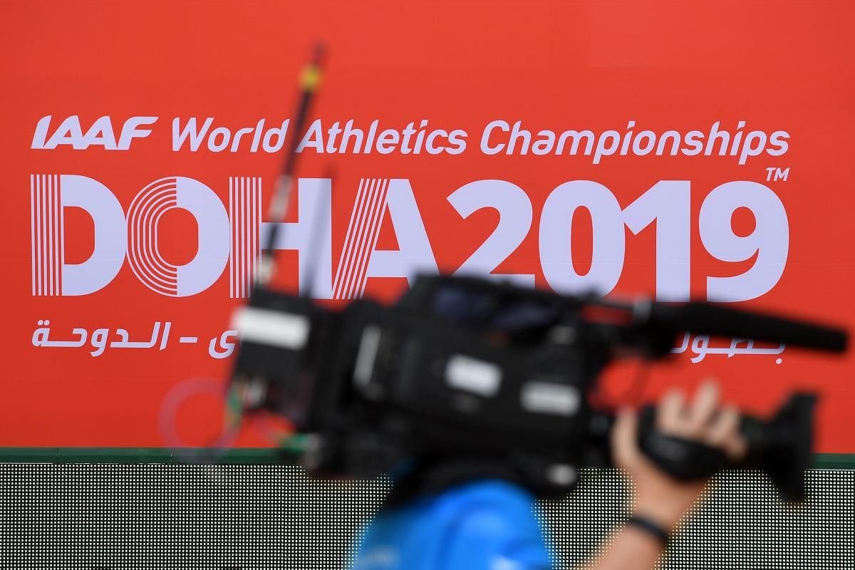 A cameraman walks past the logo of the IAAF World Athletics Championships inside the Khalifa International Stadium in Doha on September 25, 2019. (AFP)