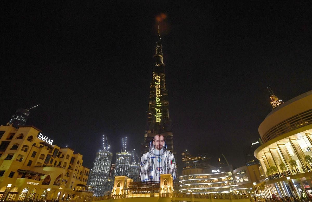 A picture taken on September 25, 2019, shows the Gulf emirate's Burj Khalifa, the world's tallest skyscraper, lit with an image of 35-year-old Emirati astronaut Hazzaa al-Mansoori, who is set to spend eight days aboard the International Space Station. AFP