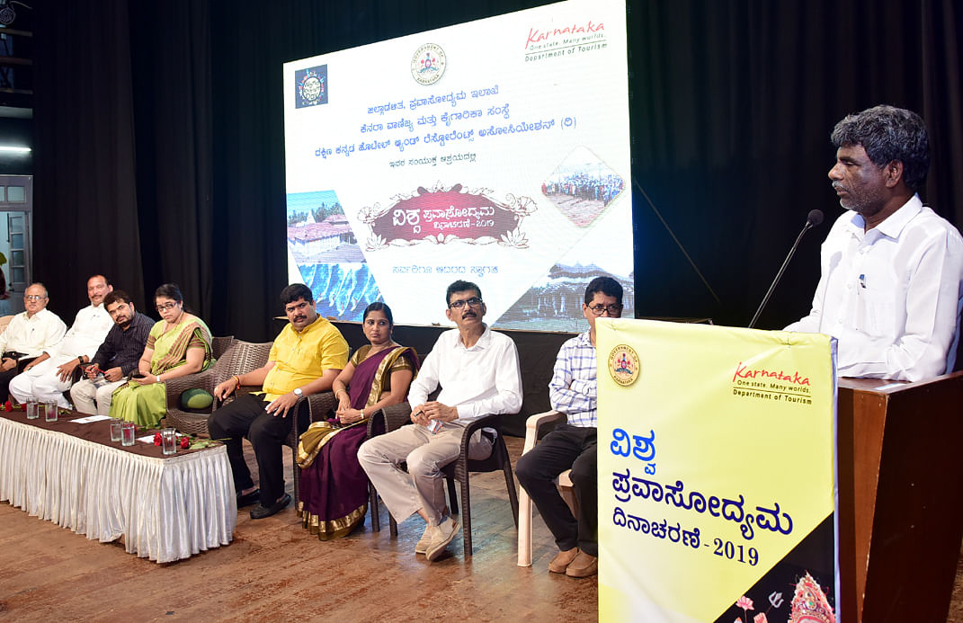 Minister for Fisheries, Port and Inland transport and district in-charge minister Kota Srinivas Poojary delivers his inaugural address at the Tourism day celebrations at Town Hall, Mangaluru.