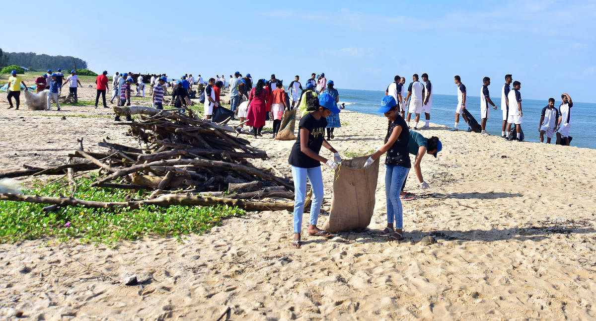 Volunteers clean the shores of Tannirbhavi beach as part of International Coastal Cleanup Day on Saturday. DH photo/Govindraj Javali