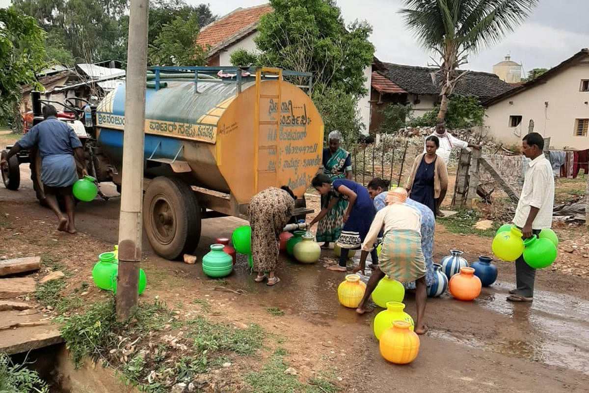 People collect water from tanker at Hosahalli in Kadur taluk. 