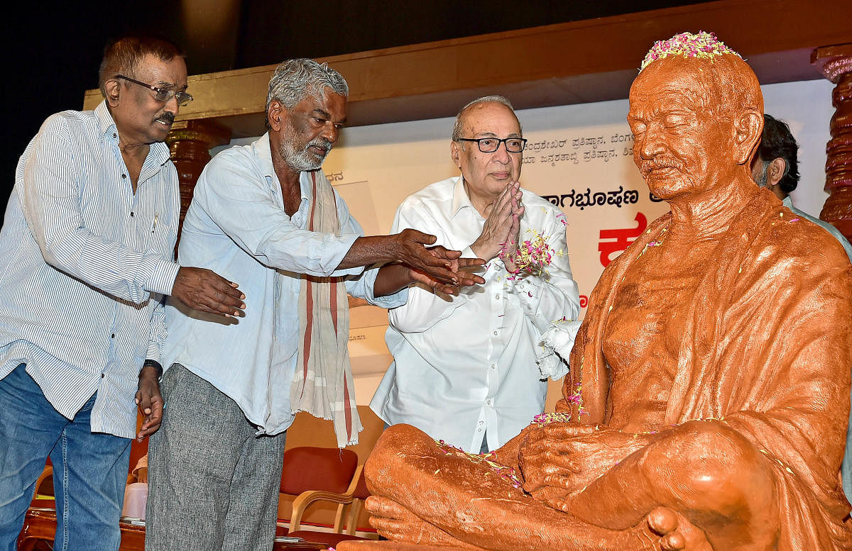 Writers D S Nagabhushan, Devanuru Mahadeva and Justice (retd) A J Sadashiva pay floral tributes to a Gandhi statue at an event on Sunday. DH PHOTO/RANJU P