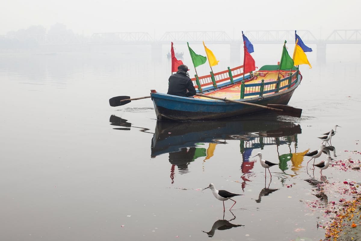 An Indian boatman rows his boat during a cold morning along the banks of the Yamuna River in Mathura in the Indian state of Uttar Pradesh. (Photo by AFP)