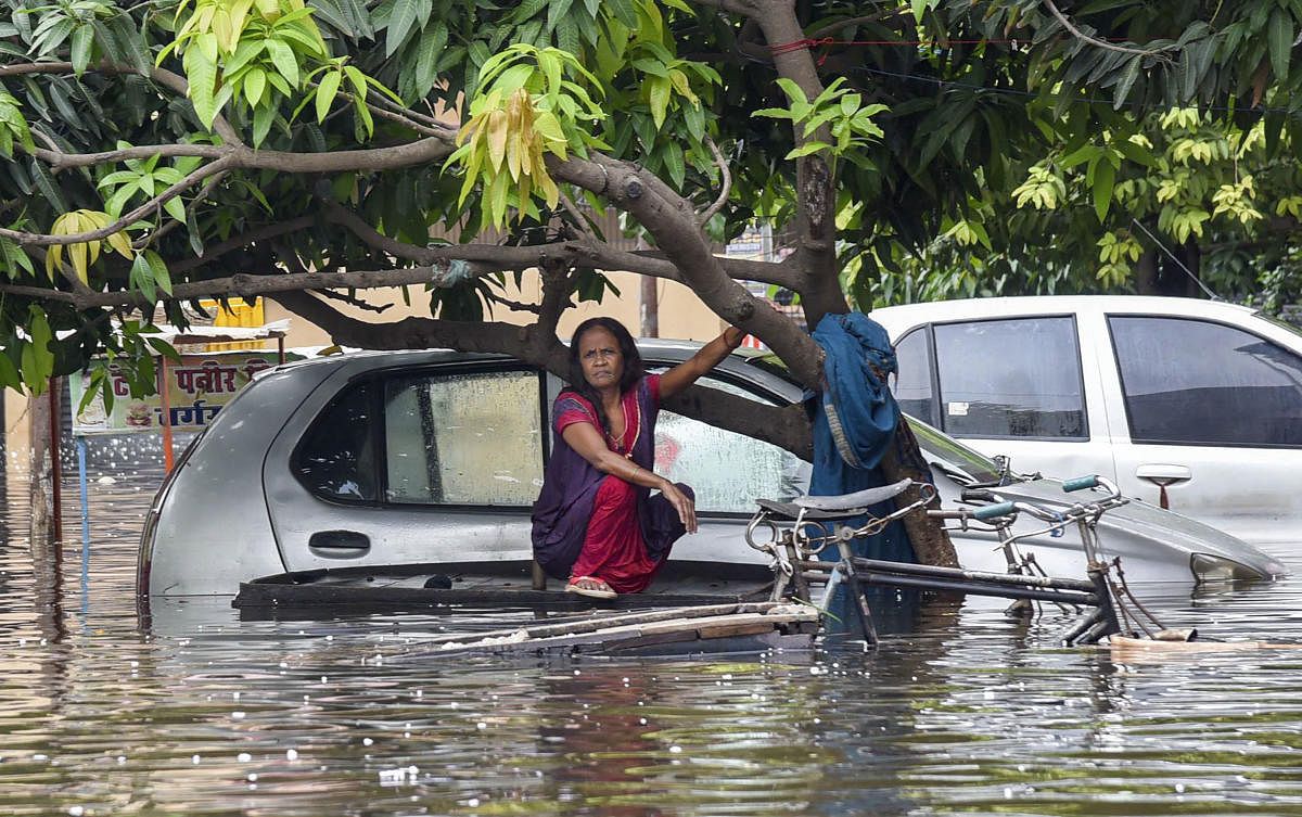 A woman sits on a cart submerged in floodwater in a flood-affected area following heavy rainfall, in Patna. Photo/PTI 