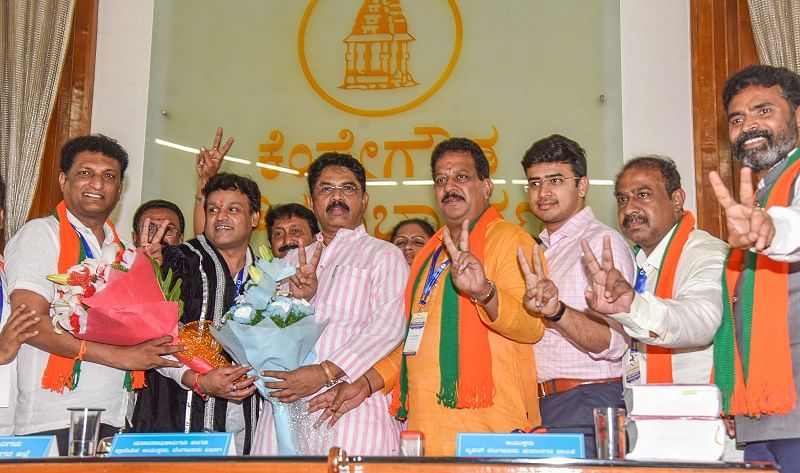 R Ashok greets C R Ramamohan Raju new deputy Mayor, M Gautham Kumar, new Mayor after BBMP Mayor and Deputy election at Kempegowda Council Hall, Bengaluru on Tuesday. S R Vishwanath, Tejasvi Suraya and others seen.