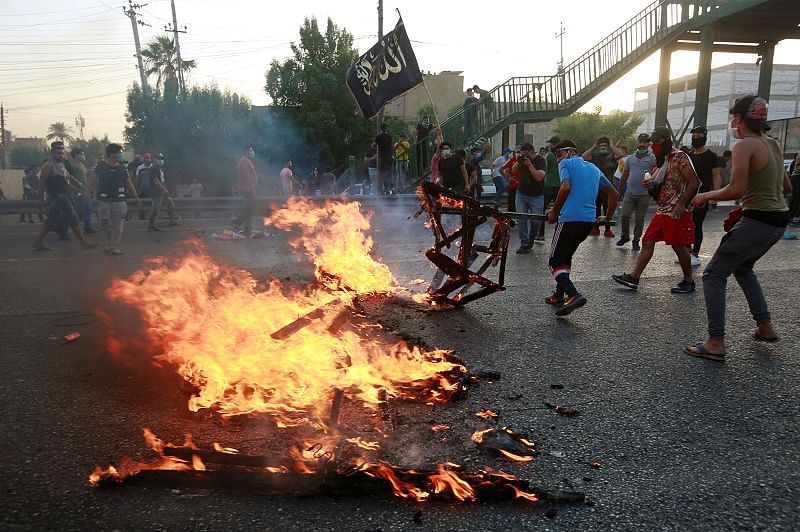 Demonstrators burn objects at a protest during a curfew, two days after the nationwide anti-government protests turned violent, in Baghdad, Iraq. (Reuters Photo)