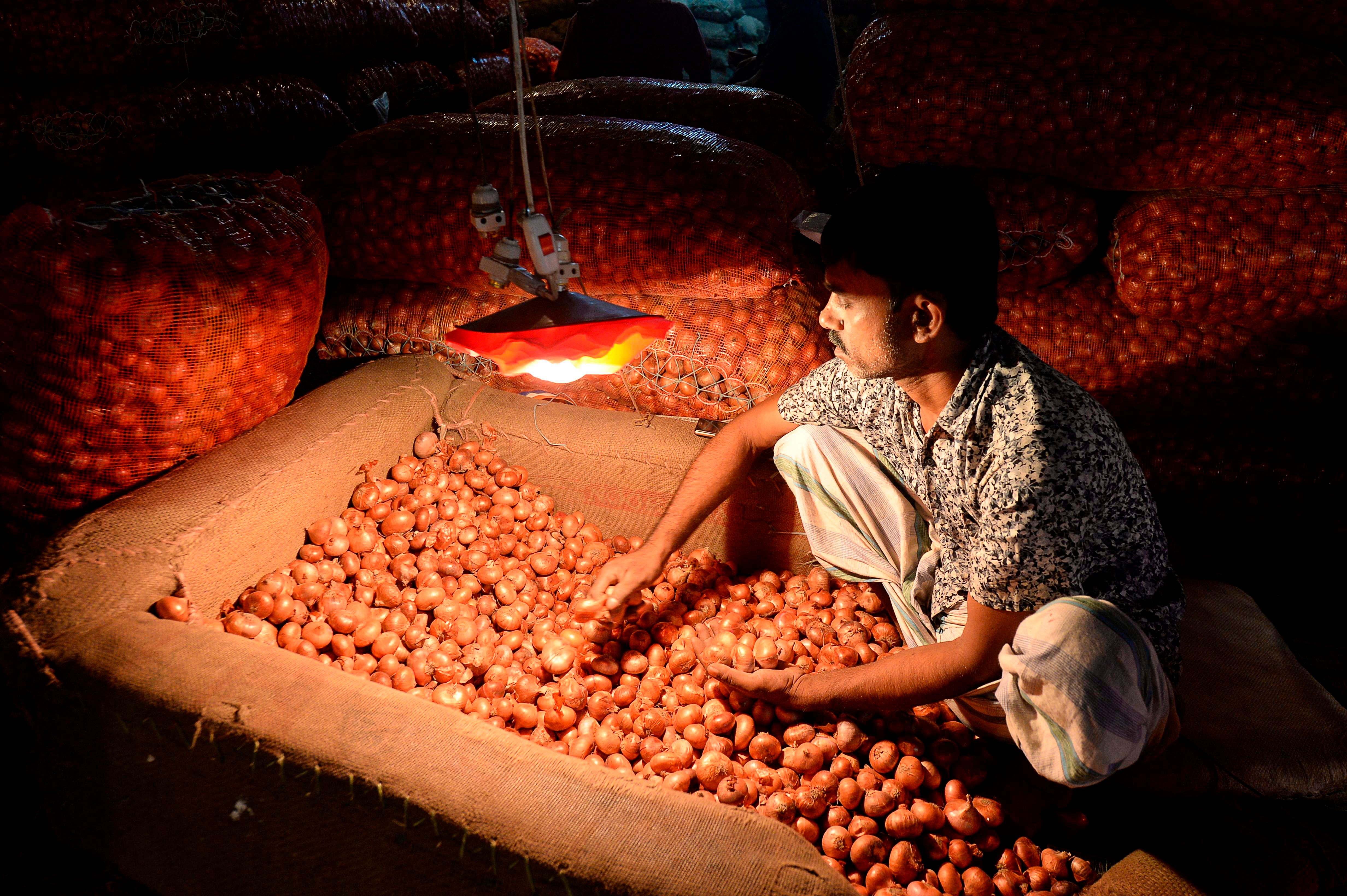 A salesman prepares onions at Kawran Bazaar wholesale market in Dhaka. (AFP Photo)