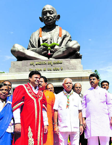 Chief Minister B S Yediyurappa near the Gandhi statue on the Vidhana Soudha premises in Bengaluru after garlanding it, on Wednesday. Mayor Goutham Kumar and Revenue Minister R Ashoka are seen. (DH Photo)