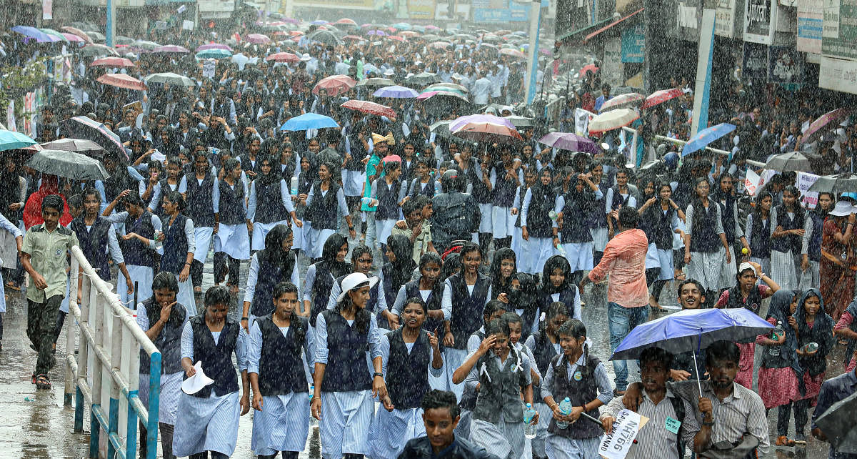 School students take part in a protest march amid rains against the night traffic ban on Kozhikode-Bengaluru National Highway (NH 766), at Sultan Bathery in Wayanad on Oct 1, 2019. (PTI Photo)