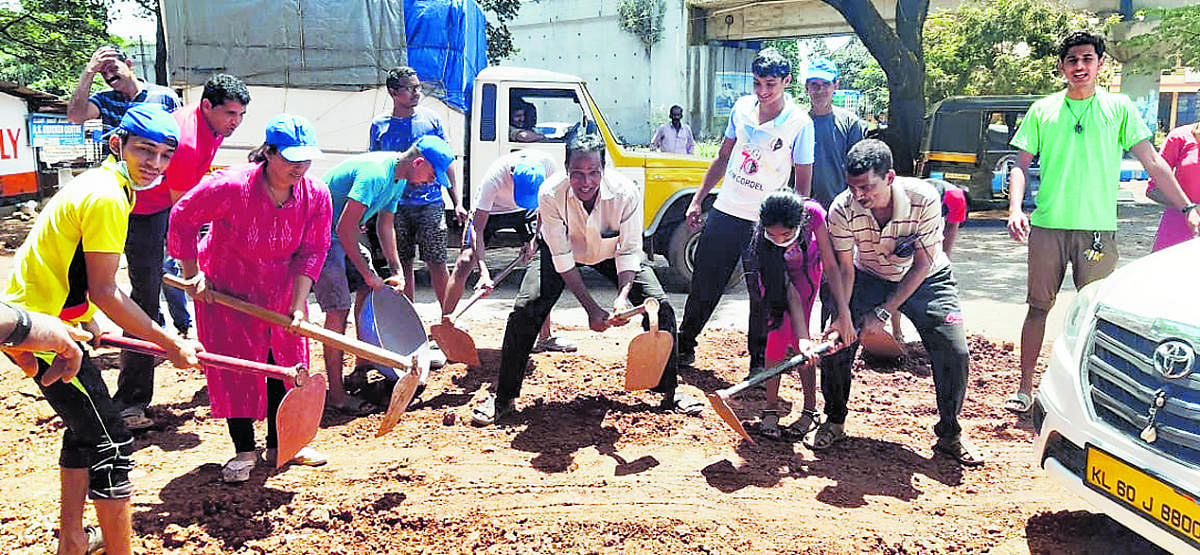 Youth engage in repairing the road by filling potholes at Kulshekar in Mangaluru on the occasion of Gandhi Jayanti on Wednesday.