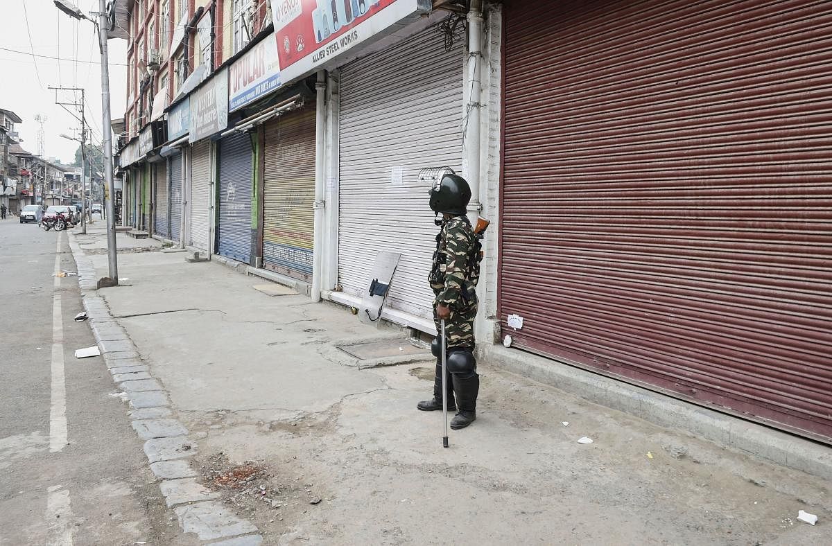 A security person stands guard during shutdown, in Srinagar on Thursday. (PTI Photo)