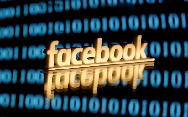 A Facebook logo is seen in front of displayed binary code in this illustration picture. (Photo/Reuters)