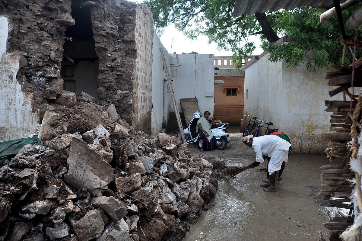Residents of Kamatagi village in Bagalkot cleans the slush following floods in the village damaging several houses in the area. | DH Photo: Pushkar V