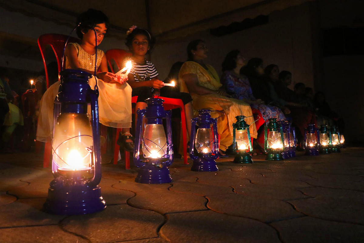 Residents of Holy Faith H2o at Maradu, one of the flats built on the coastal zone, light lamps and candles after the decison of Supreme Court on Rs 25 lakh interim compensation to each flat owner, in Kochi. (PTI Photo)