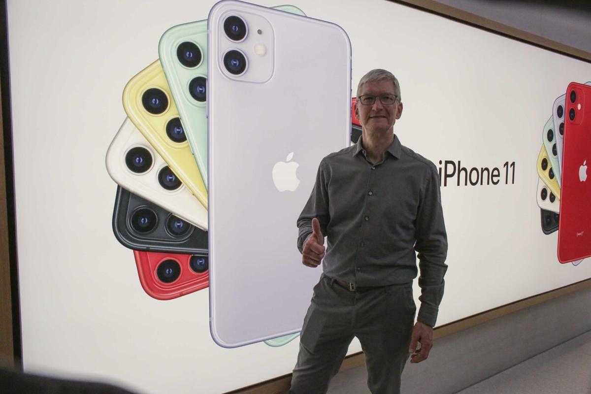 Apple CEO Tim Cook pose next to an image of the new iPhone 11 after opening the newly renovated Apple Store at Fifth Avenue on September 20, 2019 in New York City. Photo/AFP